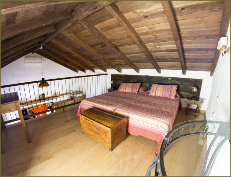 Vivienda 1 – Dormitorio con escritorio bajo techo de madera