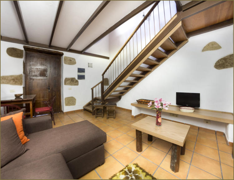Vivienda 2 – Salón con sofá y vigas de madera
