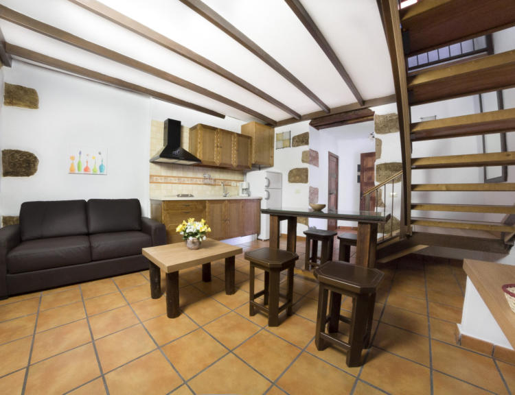Vivienda 3 – Salón con sofá y vigas de madera